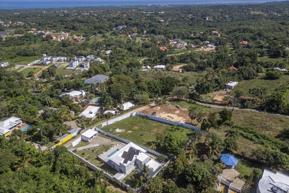 buyDRproperty Aerial view of lots for sale in La Mulata with houses and ocean views. Sosua Real Estate