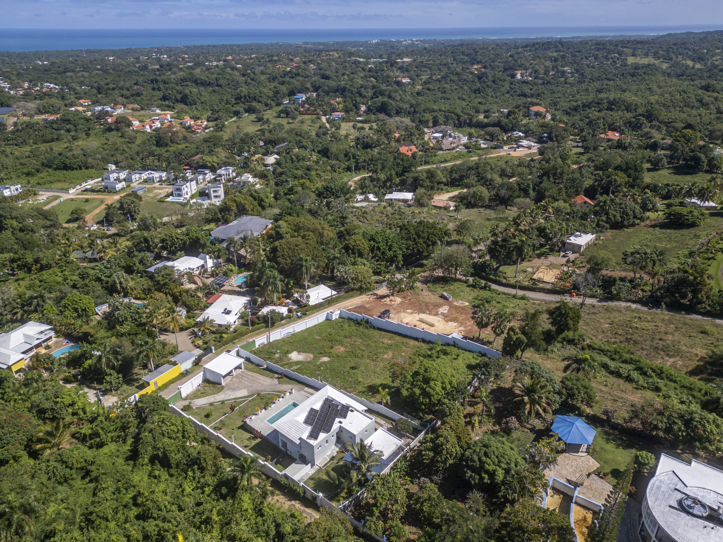 buyDRproperty Aerial view of lots for sale in La Mulata with houses and ocean views. Sosua Real Estate