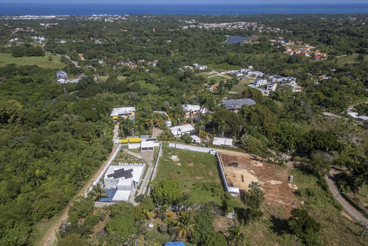 buyDRproperty Aerial view of La Mulata lots for sale with ocean views, some with solar panels. Sosua Real Estate