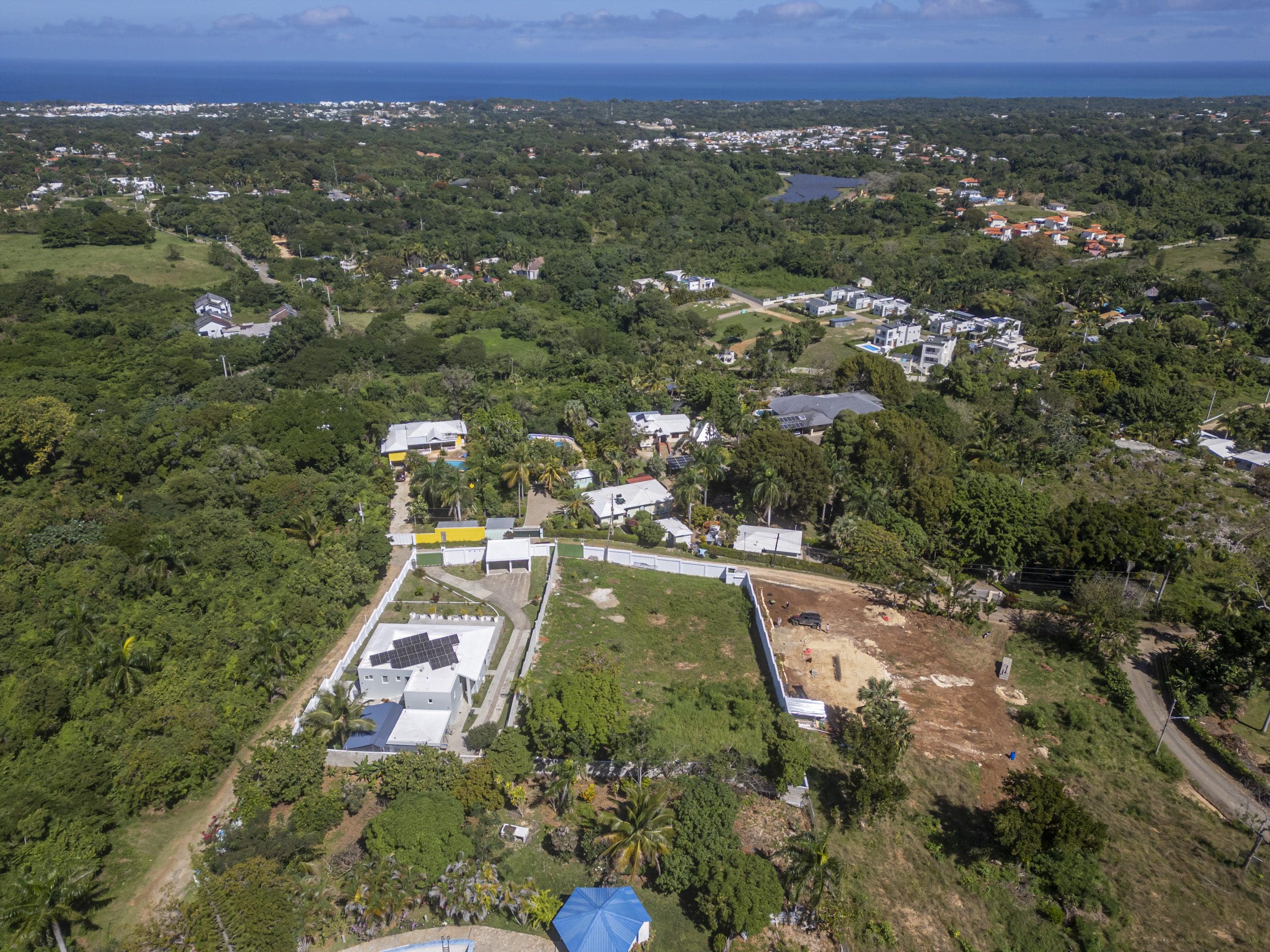 buyDRproperty Aerial view of La Mulata lots for sale with ocean views, some with solar panels. Sosua Real Estate