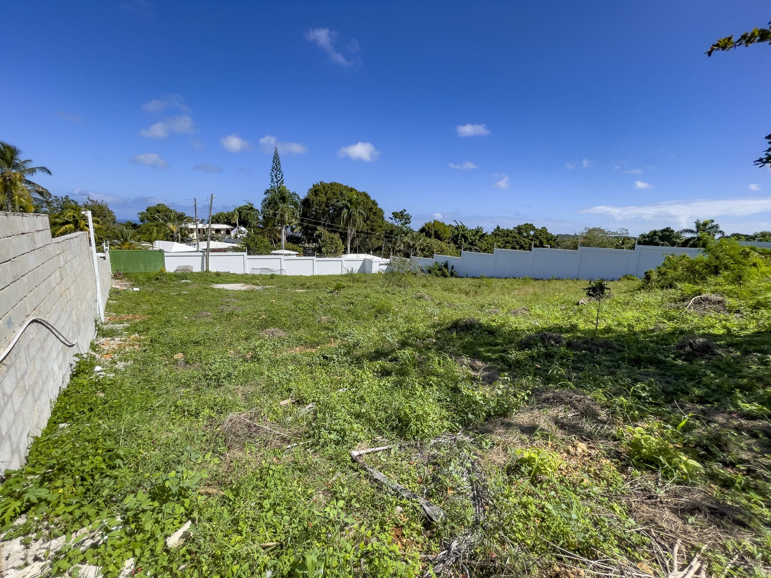 buyDRproperty Vacant lot for sale in La Mulata with white wall and blue sky. Sosua Real Estate