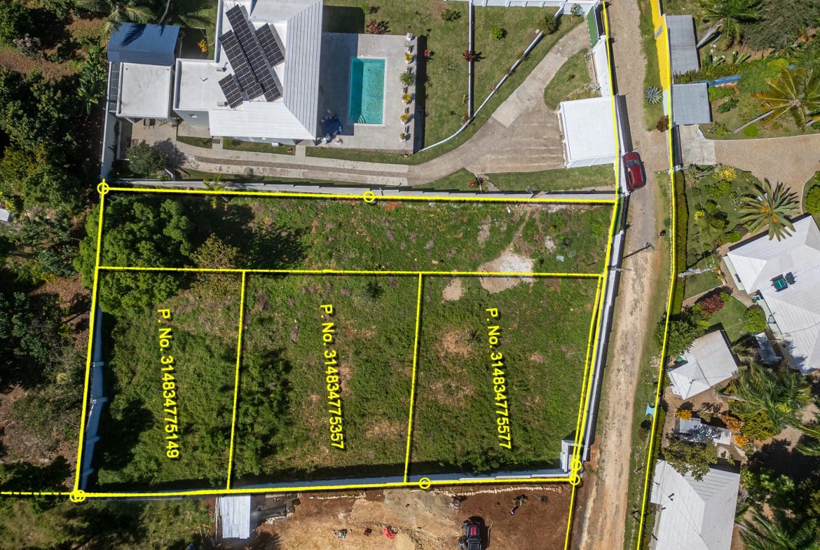 buyDRproperty Aerial view of lots for sale in La Mulata, featuring property lines and surrounding homes. Sosua Real Estate