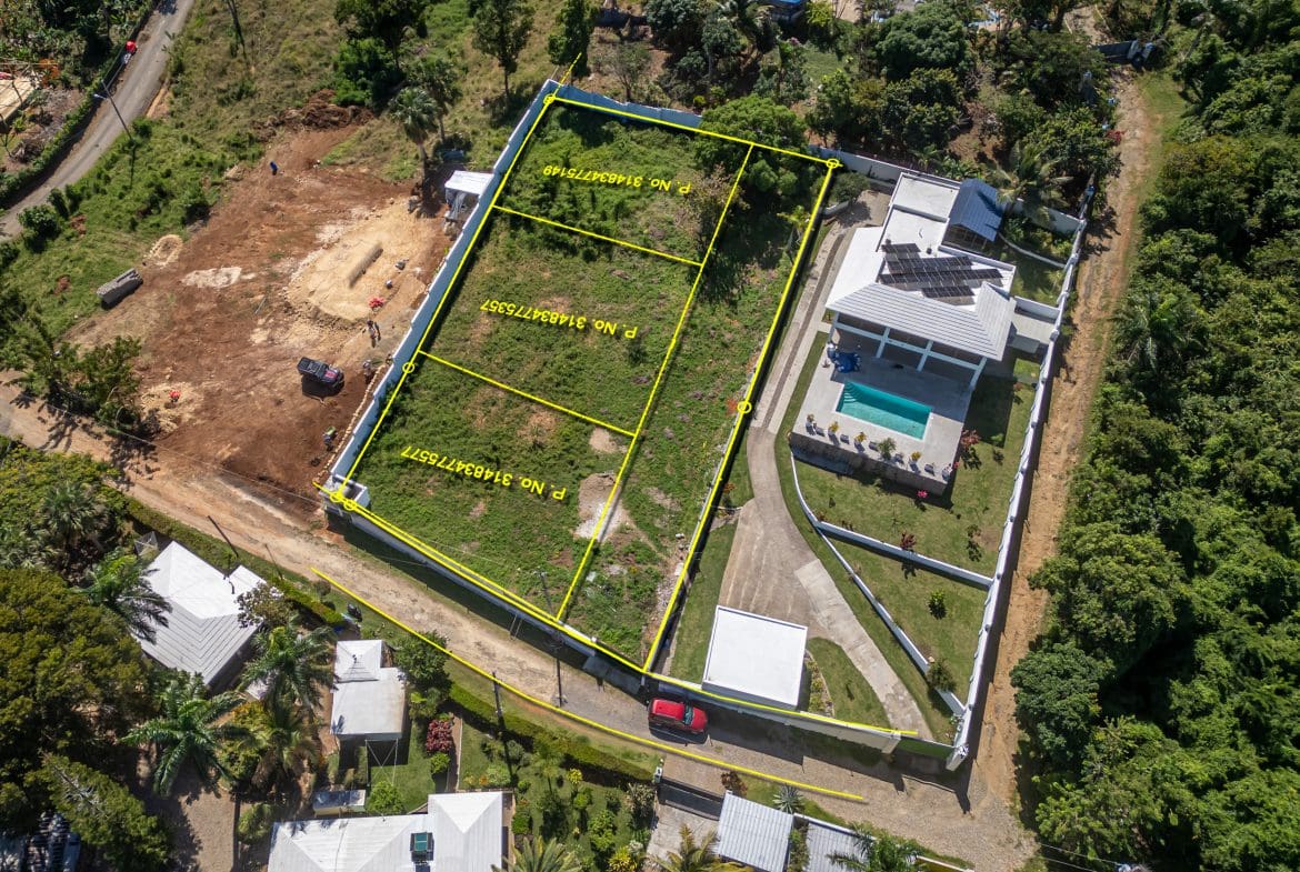 buyDRproperty Aerial view of lots for sale in La Mulata, featuring marked land parcels and a house with a pool. Sosua Real Estate