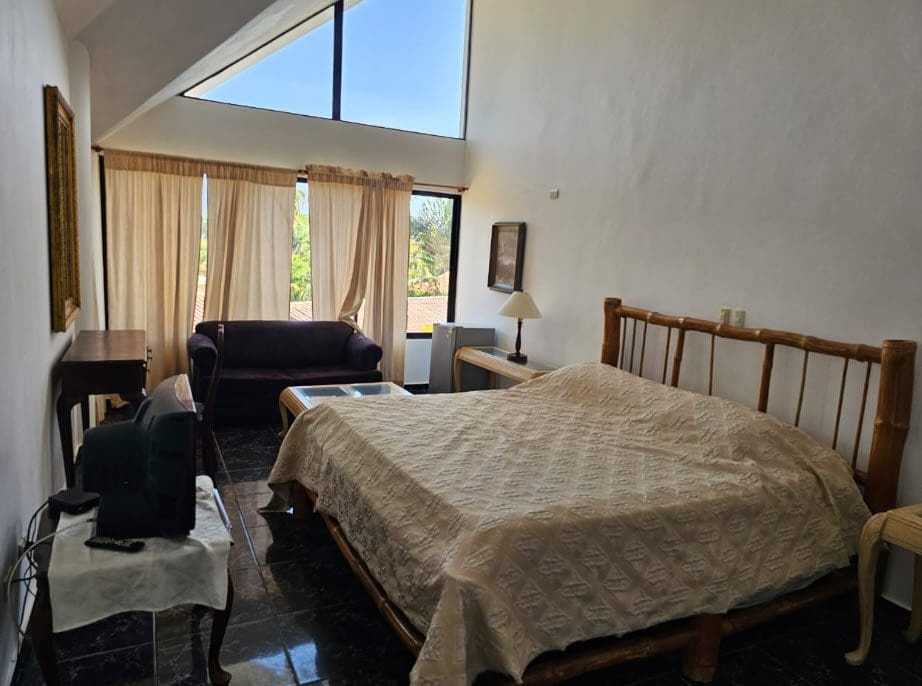 buyDRproperty Hotel room near the beach with bed, sofa, and large window. Sosua Real Estate
