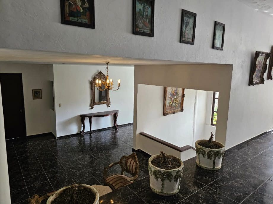 buyDRproperty Interior view of a hotel near the beach, showcasing a chandelier, artwork, and tiled floor. Sosua Real Estate