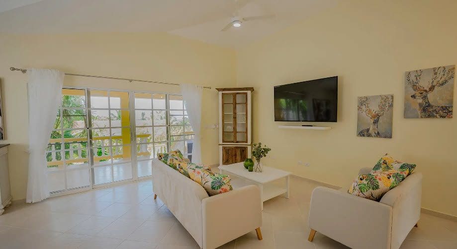 buyDRproperty Living room of a Wonderful 3 Bedroom Villa with a TV and deer artwork. Sosua Real Estate