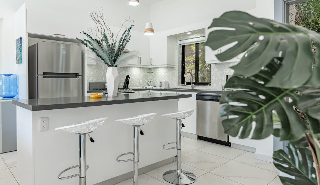 buyDRproperty Modern kitchen in the Beautiful Villa CAPRI with bar stools and stainless steel appliances. Sosua Real Estate