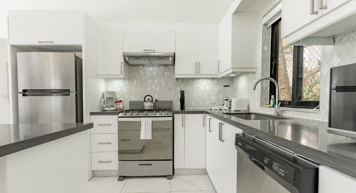 buyDRproperty Modern white kitchen with stainless steel appliances. Beautiful Villa CAPRI. Sosua Real Estate