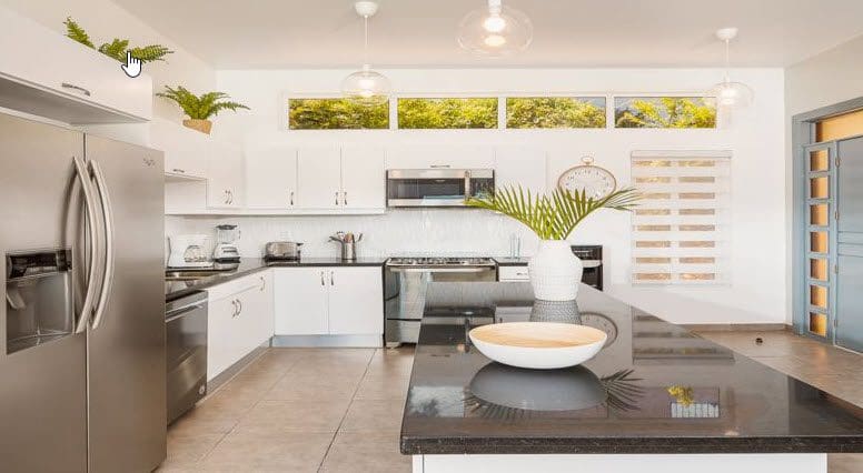 buyDRproperty Beautiful Villa SUNBREEZE kitchen with white cabinets and stainless steel appliances. Sosua Real Estate