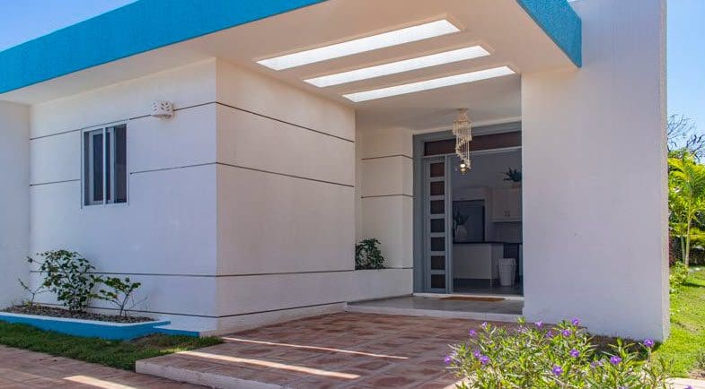 buyDRproperty Beautiful Villa SUNBREEZE exterior with blue accents and entryway Sosua Real Estate