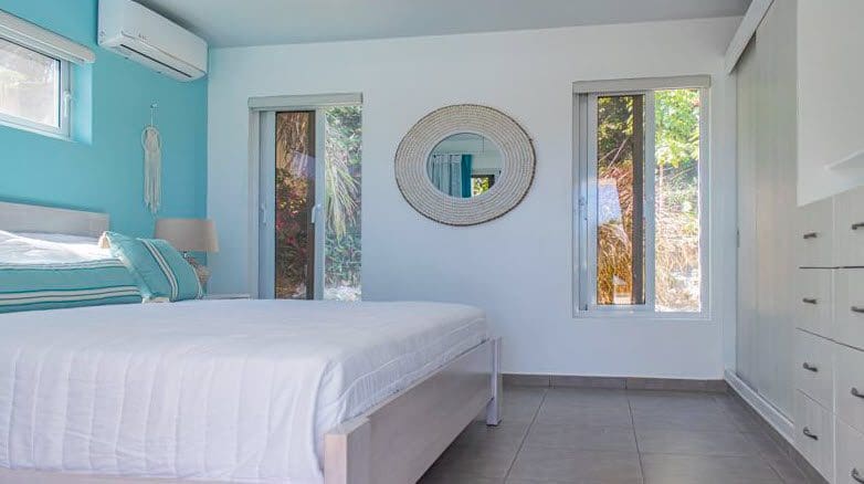 buyDRproperty Bedroom in Beautiful Villa SUNBREEZE with white bedding and a mirror. Sosua Real Estate