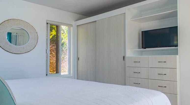 buyDRproperty Bedroom in Beautiful Villa SUNBREEZE with white walls and a large mirror. Sosua Real Estate