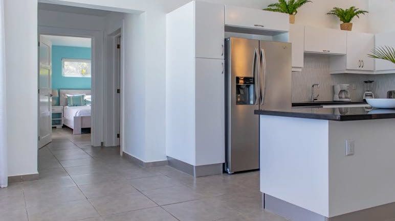 buyDRproperty Modern kitchen in a Beautiful Villa SUNBREEZE with stainless steel refrigerator and view to bedroom. Sosua Real Estate