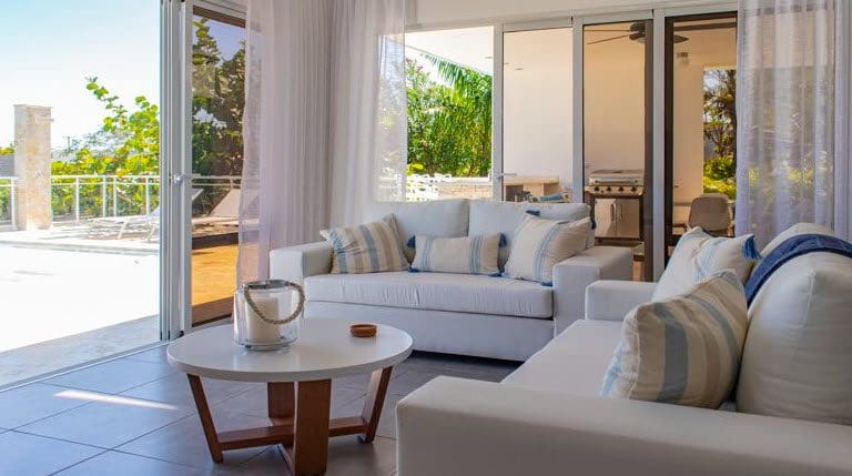 buyDRproperty Beautiful Villa SUNBREEZE living room with white sofa and outdoor view. Sosua Real Estate