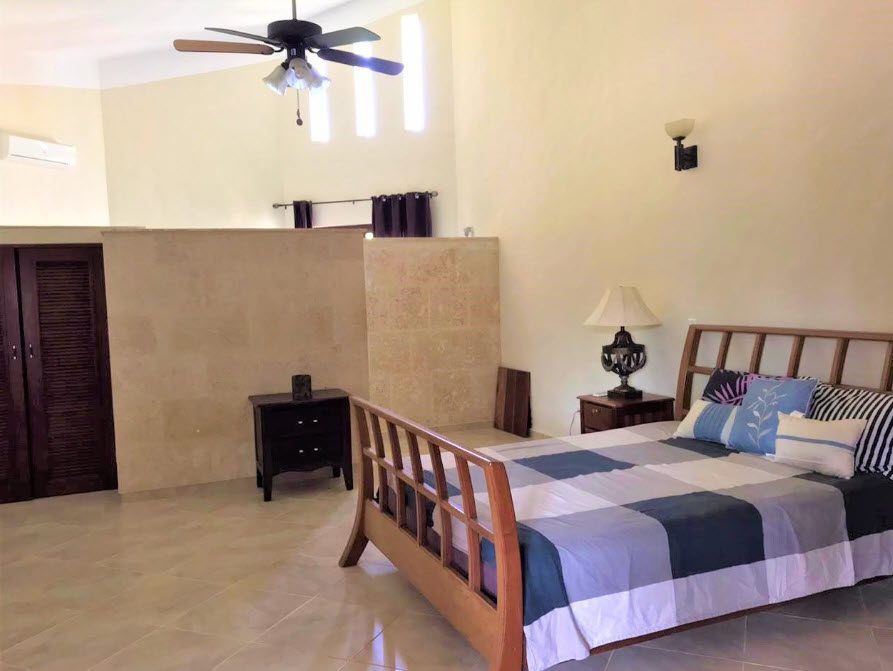 buyDRproperty Bedroom in a beautiful 5 bedroom villa with a bed, nightstand, and tile floor. Sosua Real Estate