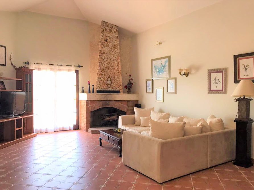 buyDRproperty Living room of a beautiful 5 bedroom villa with fireplace and sofa. Sosua Real Estate