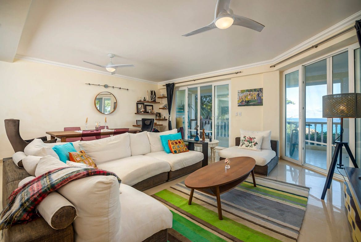 buyDRproperty Oceanfront condo living room in Sosua with white sofa and ocean views Sosua Real Estate