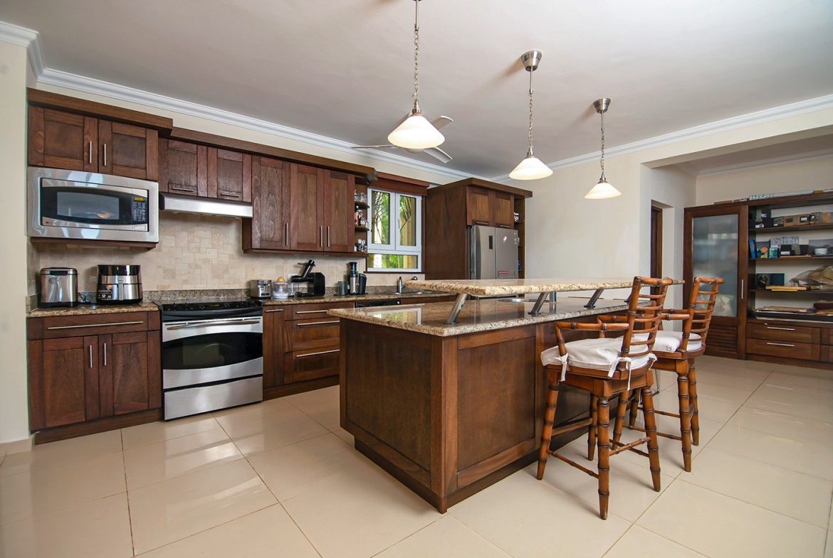 buyDRproperty Luxury kitchen with dark wood cabinets and a granite countertop in an oceanfront condo in Sosua. Sosua Real Estate