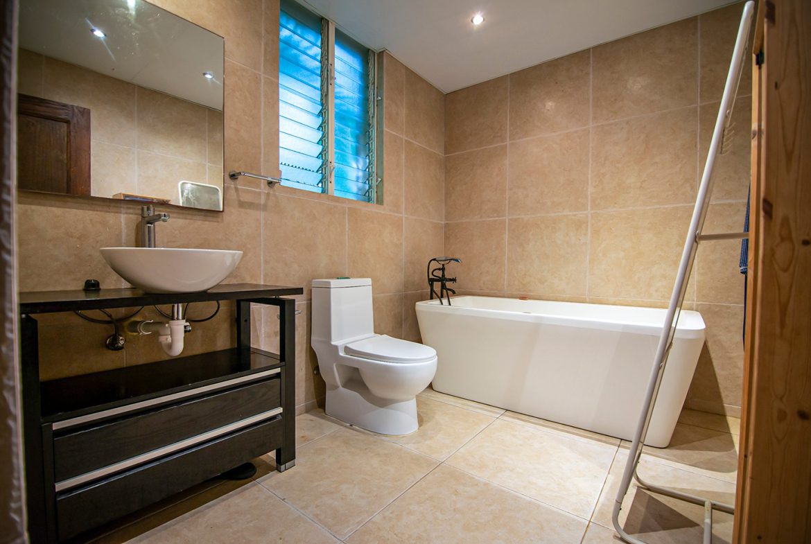 buyDRproperty Modern bathroom with a white soaking tub, toilet, and vessel sink. Oceanfront condo in Sosua. Sosua Real Estate