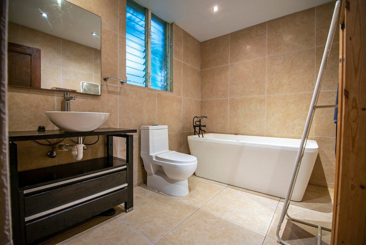 buyDRproperty Modern bathroom with a white soaking tub, toilet, and vessel sink. Oceanfront condo in Sosua. Sosua Real Estate