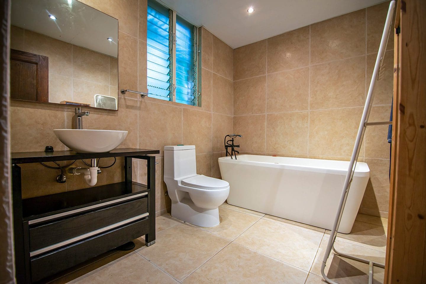 buyDRproperty Modern bathroom with a white soaking tub, toilet, and vessel sink. Oceanfront condo in Sosua. Sosua Real Estate