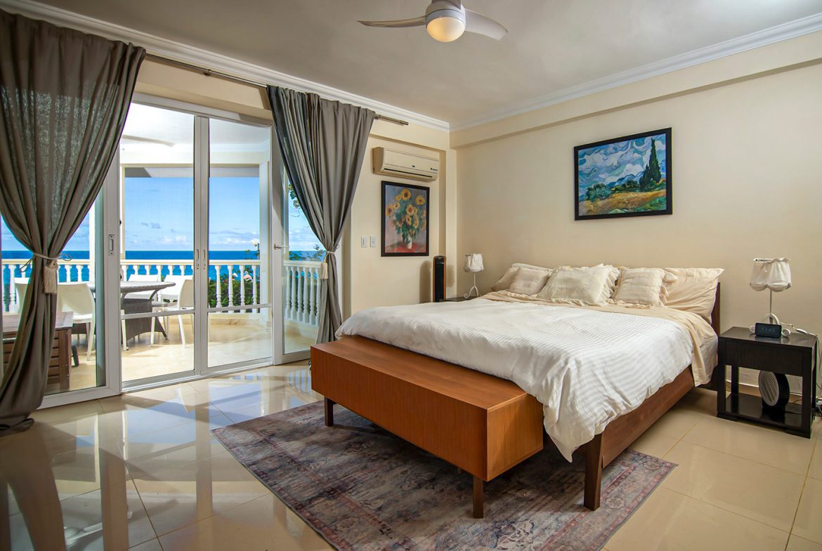 buyDRproperty Ocean view bedroom in an oceanfront condo in Sosua, with balcony access. Sosua Real Estate
