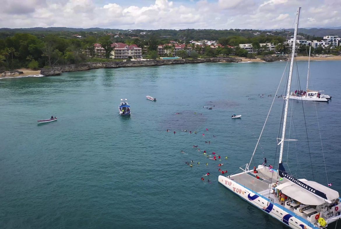 buyDRproperty Aerial view of ocean with boats and snorkelers off the coast of Sosua. 3 Bedroom Oceanfront Condo for sale. Sosua Real Estate