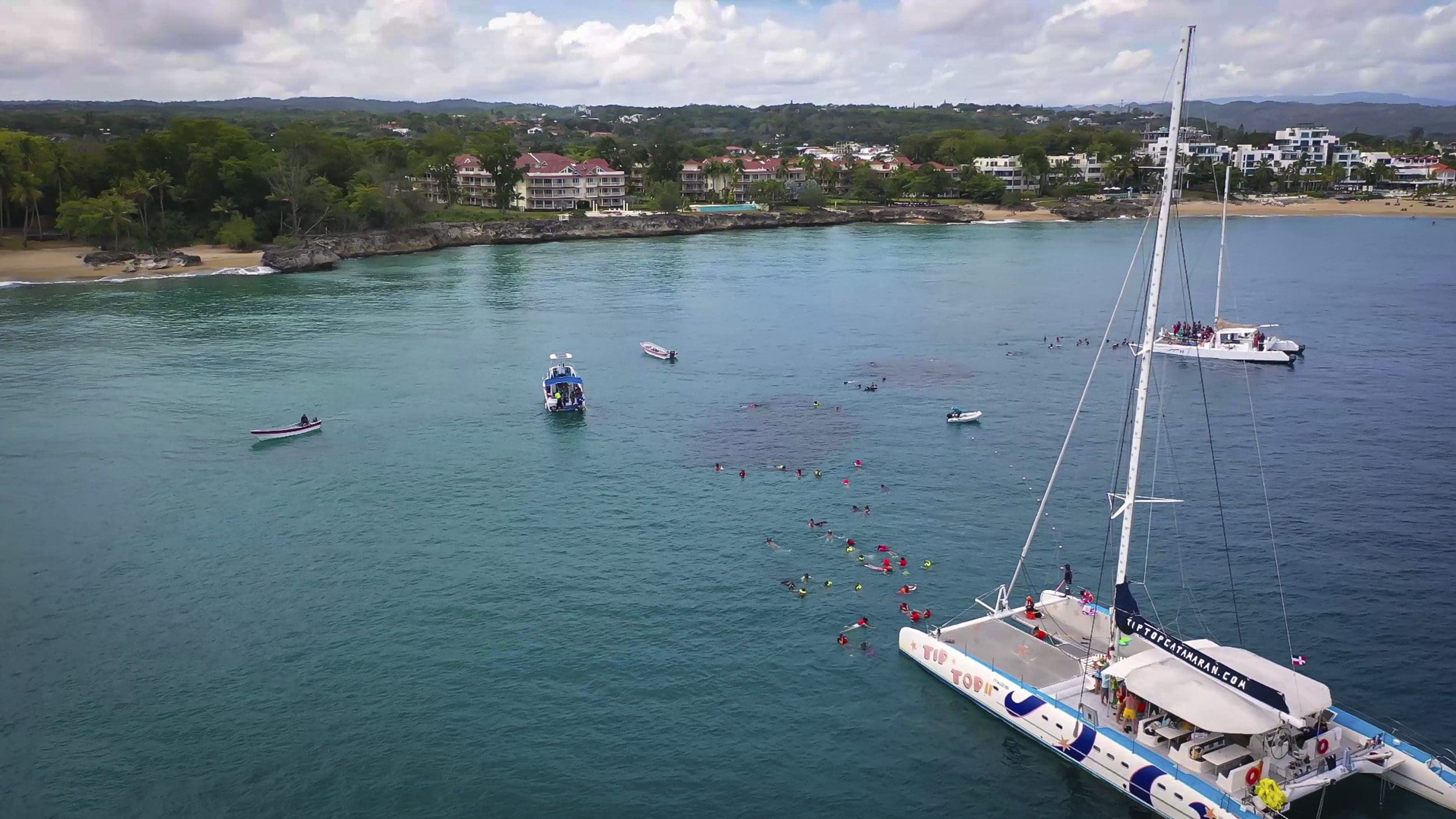 buyDRproperty Aerial view of ocean with boats and snorkelers off the coast of Sosua. 3 Bedroom Oceanfront Condo for sale. Sosua Real Estate