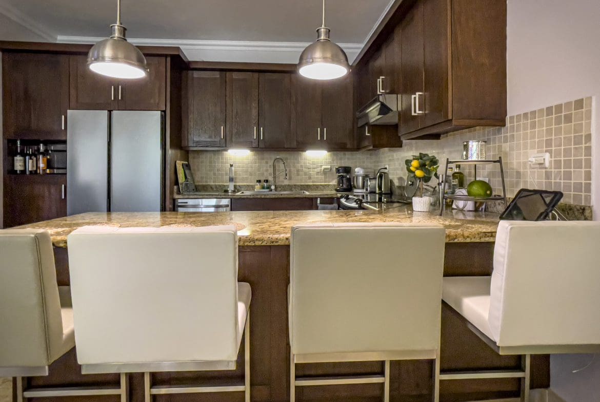 buyDRproperty Modern kitchen with granite countertop and bar seating in a 3 Bedroom Oceanfront Condo. Sosua Real Estate