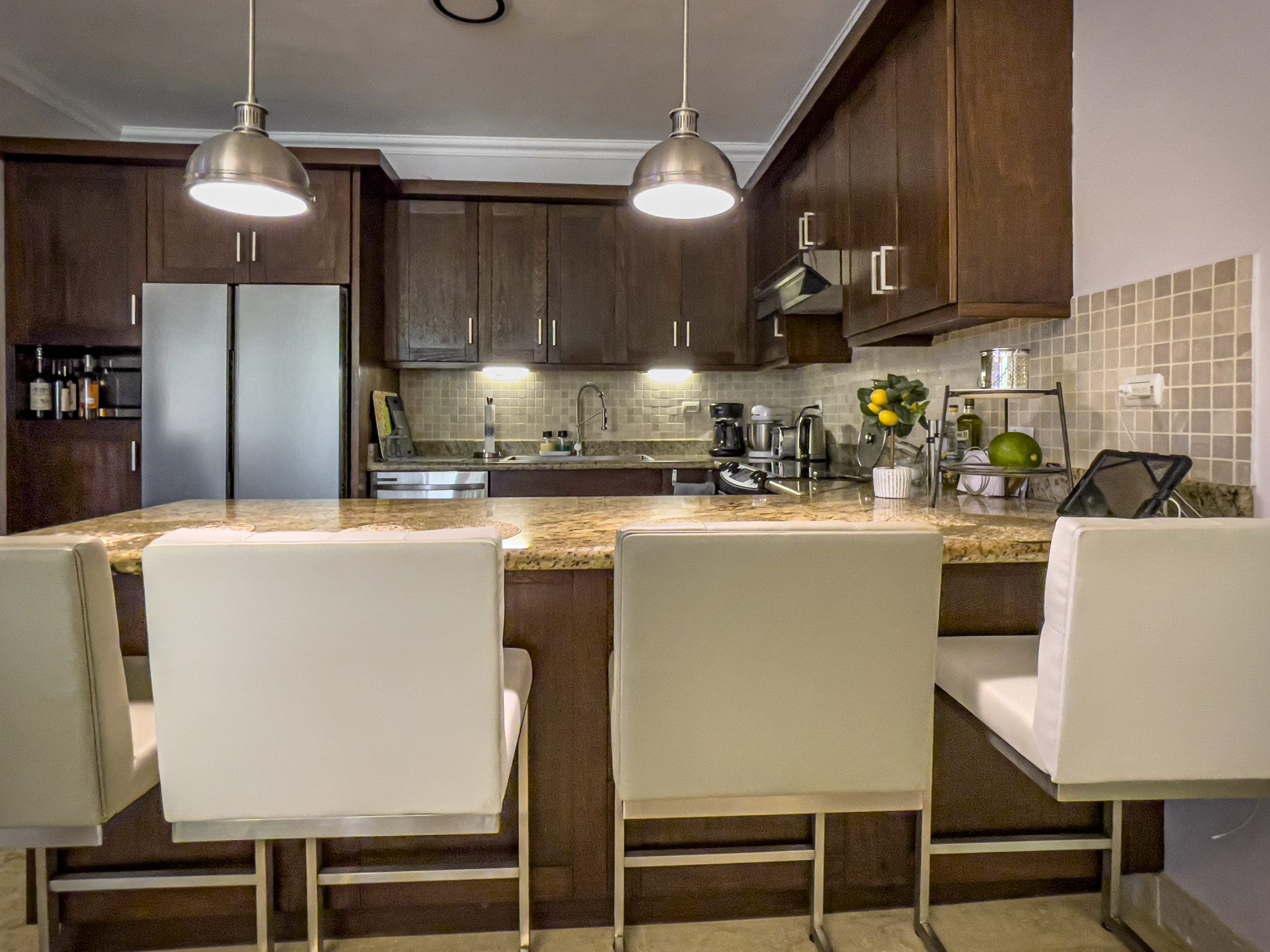 buyDRproperty Modern kitchen with granite countertop and bar seating in a 3 Bedroom Oceanfront Condo. Sosua Real Estate