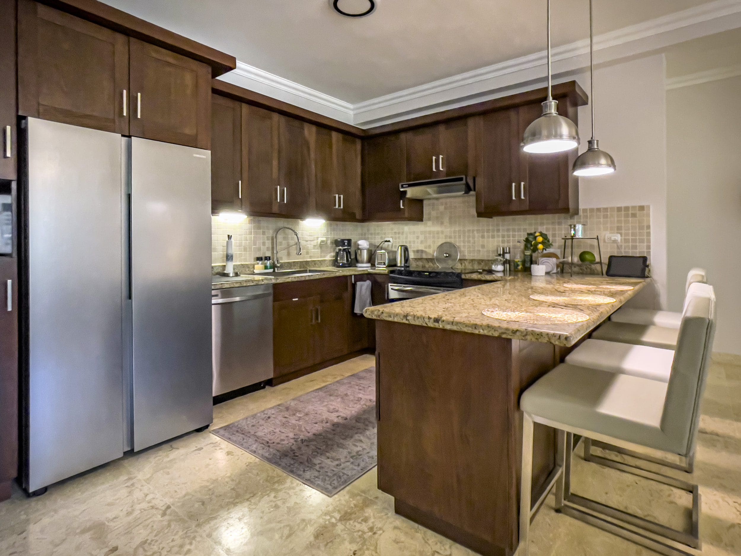 buyDRproperty Modern kitchen in a 3 Bedroom Oceanfront Condo with stainless steel appliances and breakfast bar. Sosua Real Estate