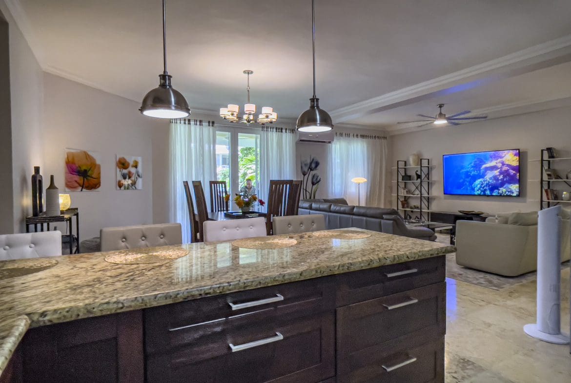 buyDRproperty Open-concept living area in a 3 bedroom oceanfront condo featuring a kitchen island and dining area. Sosua Real Estate