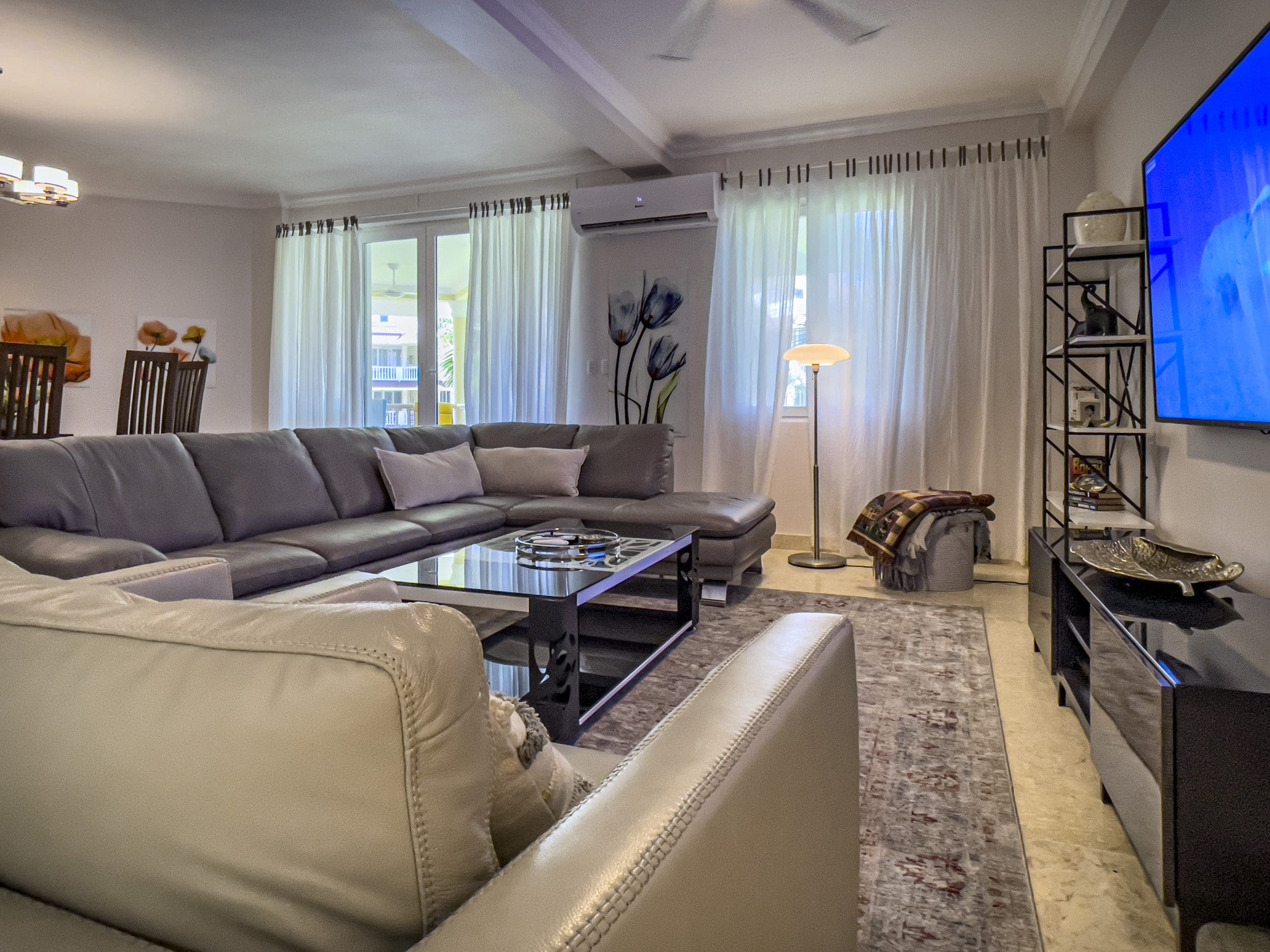 buyDRproperty Luxurious living room in a 3 bedroom oceanfront condo. Features a sectional sofa and stylish decor. Sosua Real Estate