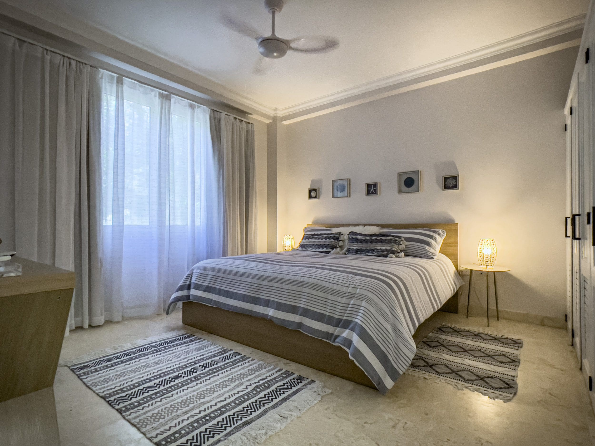 buyDRproperty Coastal bedroom with a striped comforter, rugs, and a 3 bedroom oceanfront condo feel. Sosua Real Estate