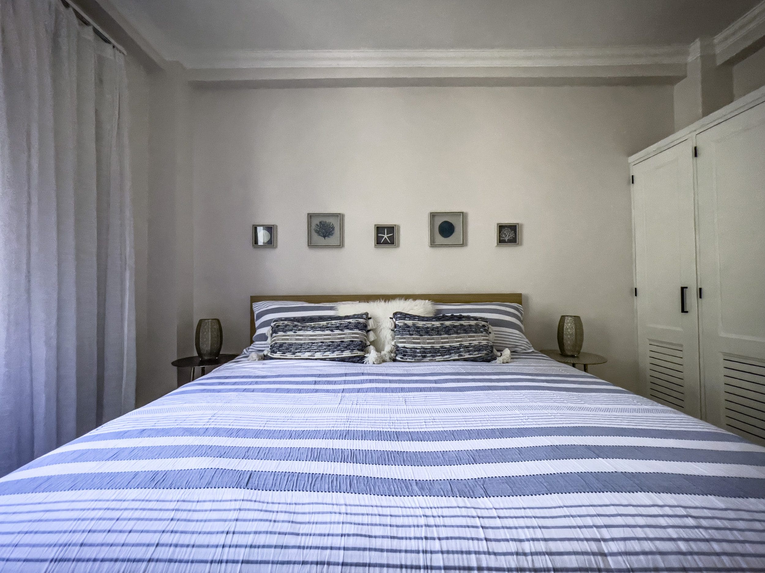 buyDRproperty Bedroom with blue and white striped bedding in 3 Bedroom Oceanfront Condo. Sosua Real Estate