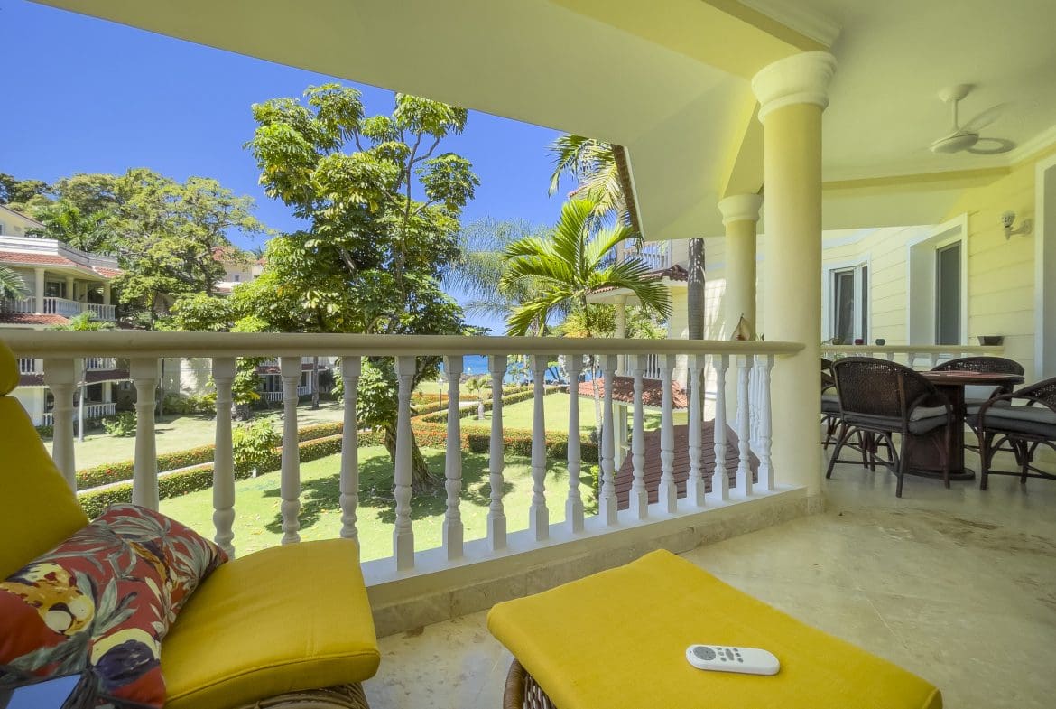 buyDRproperty Balcony of a 3 bedroom oceanfront condo with views of the ocean and lush greenery. Sosua Real Estate