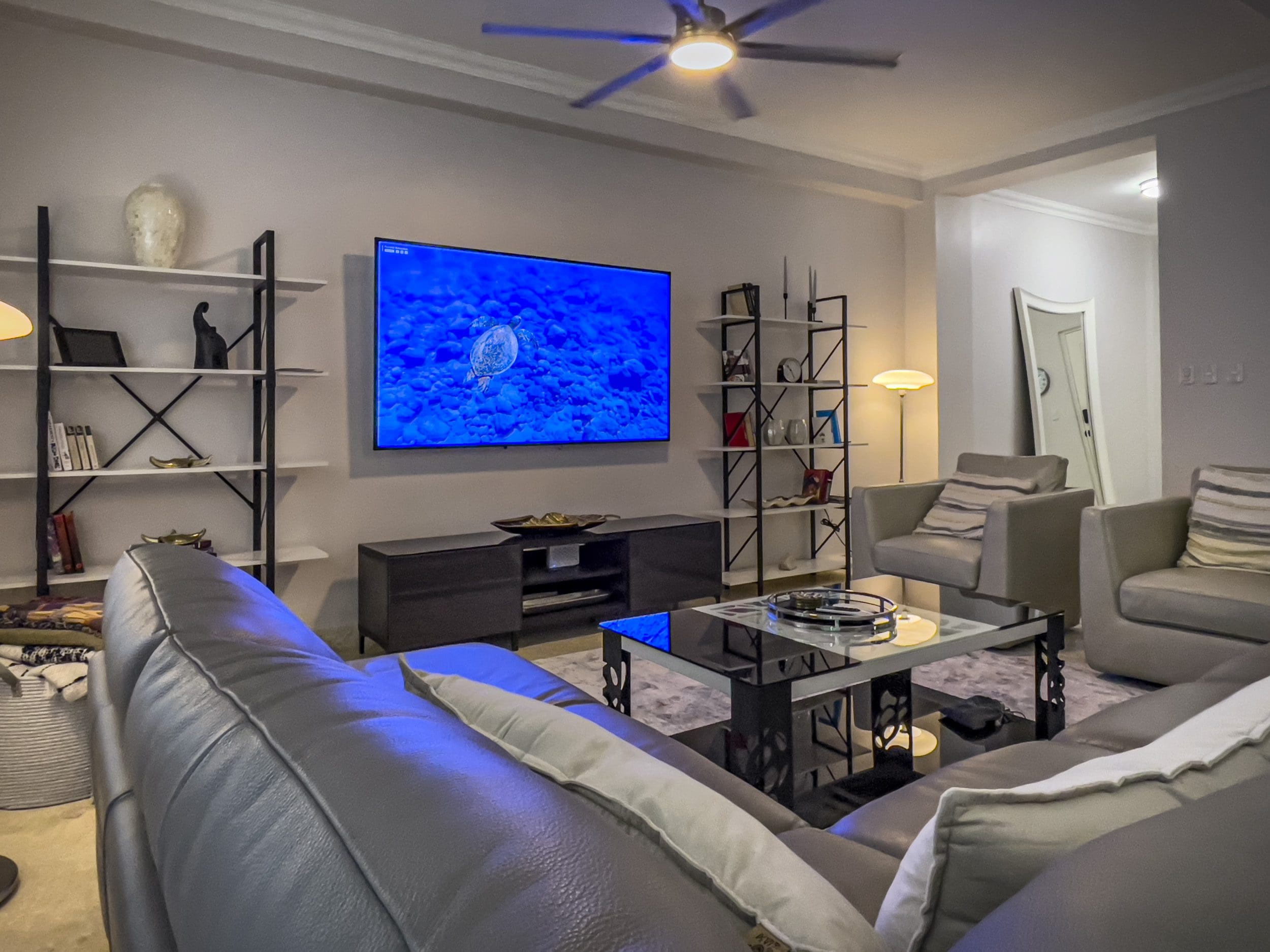 buyDRproperty Living room of a 3 bedroom oceanfront condo with a large TV and comfortable seating. Sosua Real Estate