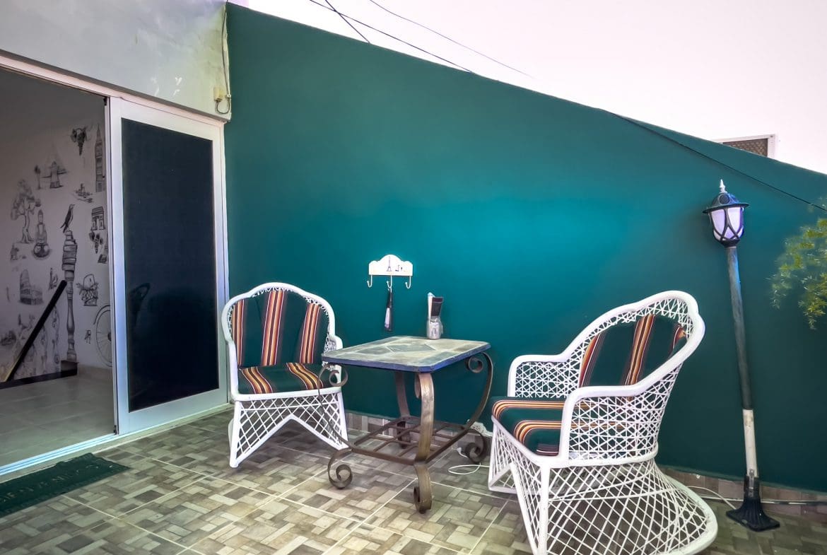 buyDRproperty Patio area with white wicker chairs and small table in a Sosua condo. Sosua Real Estate