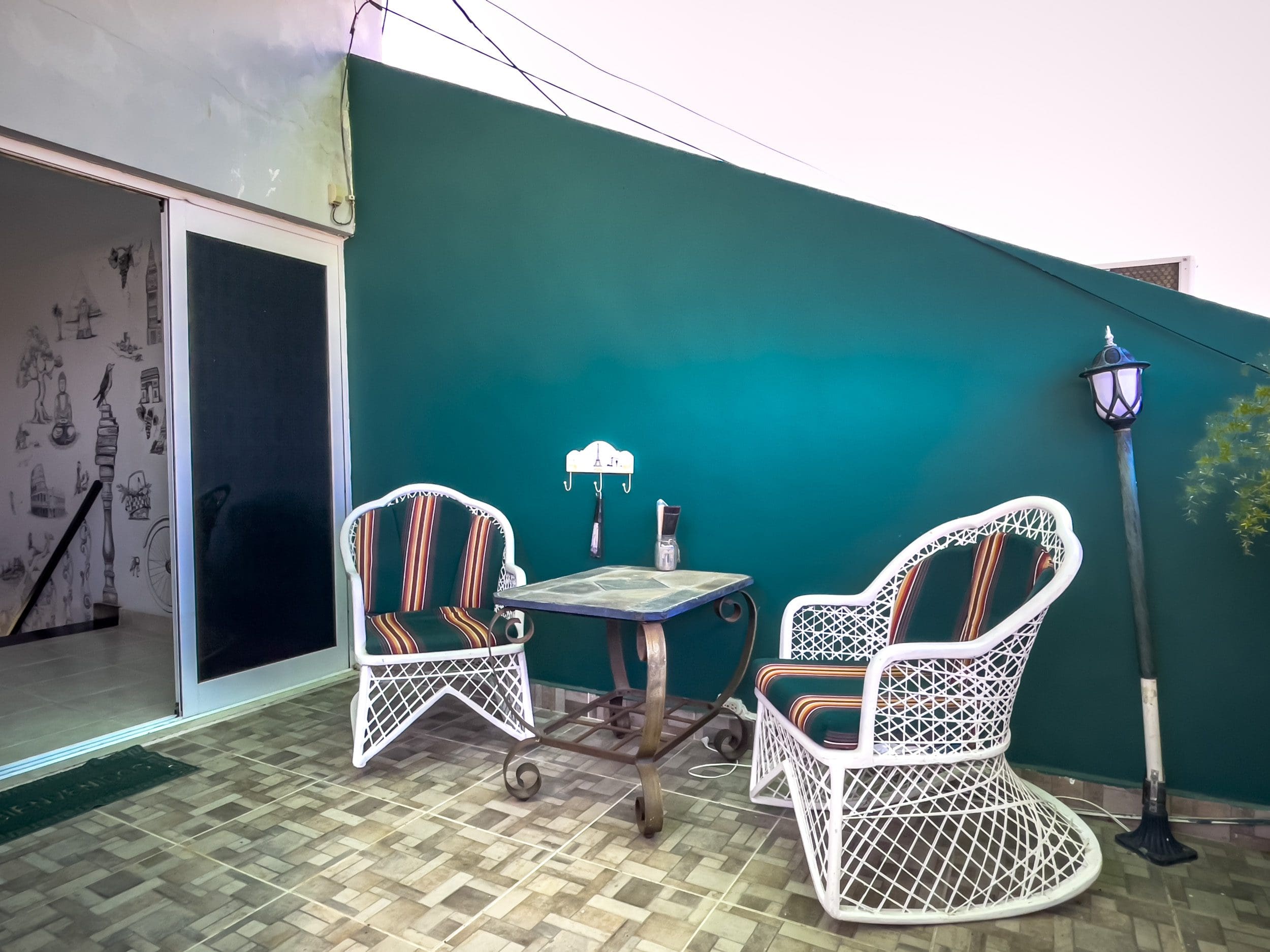 buyDRproperty Patio area with white wicker chairs and small table in a Sosua condo. Sosua Real Estate