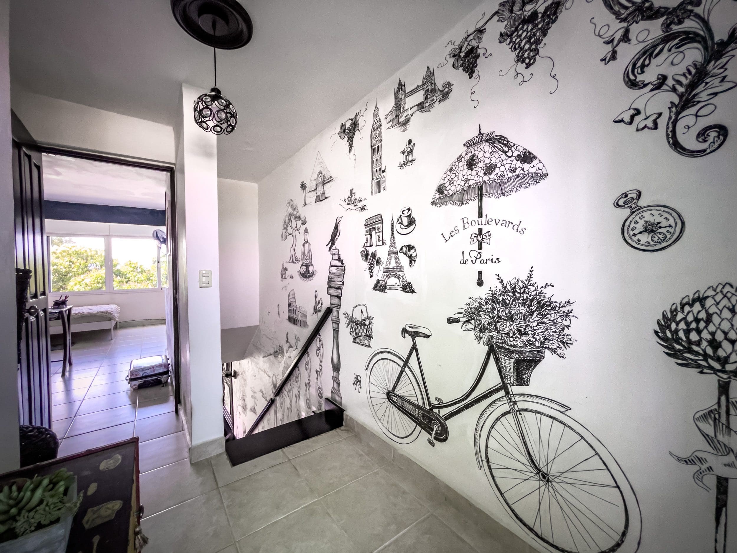 buyDRproperty Hallway with Paris-themed mural, leading to a 2-bedroom condo in Sosua. Sosua Real Estate