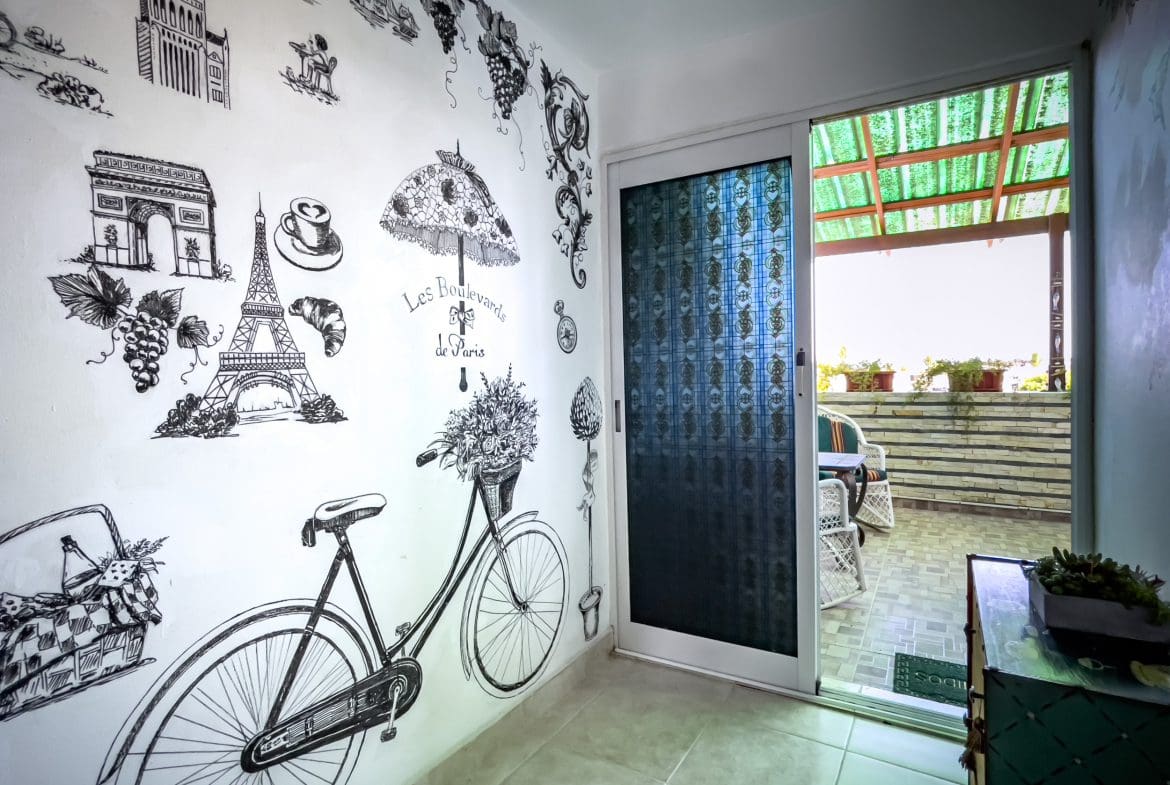 buyDRproperty Parisian wall art and balcony view in a 2 bedroom condo in the heart of Sosua. Sosua Real Estate