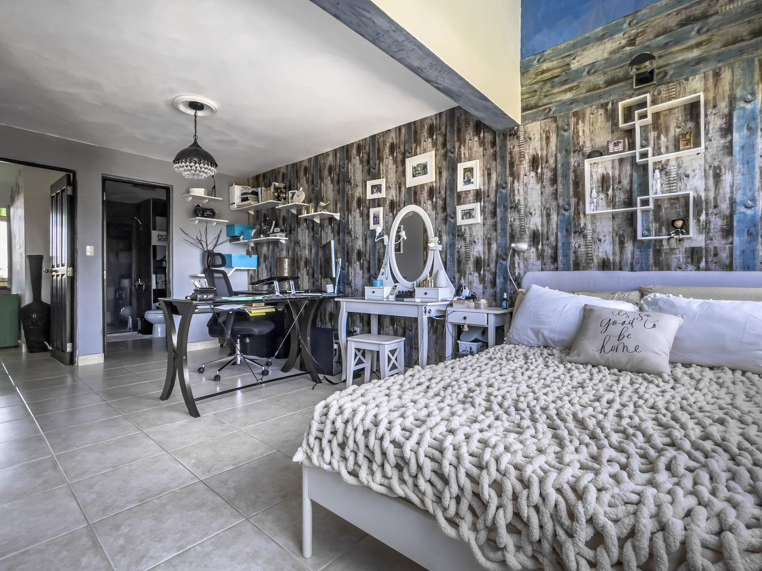 buyDRproperty Bedroom in a 2-bedroom condo in Sosua with a cozy bed and vanity. Sosua Real Estate