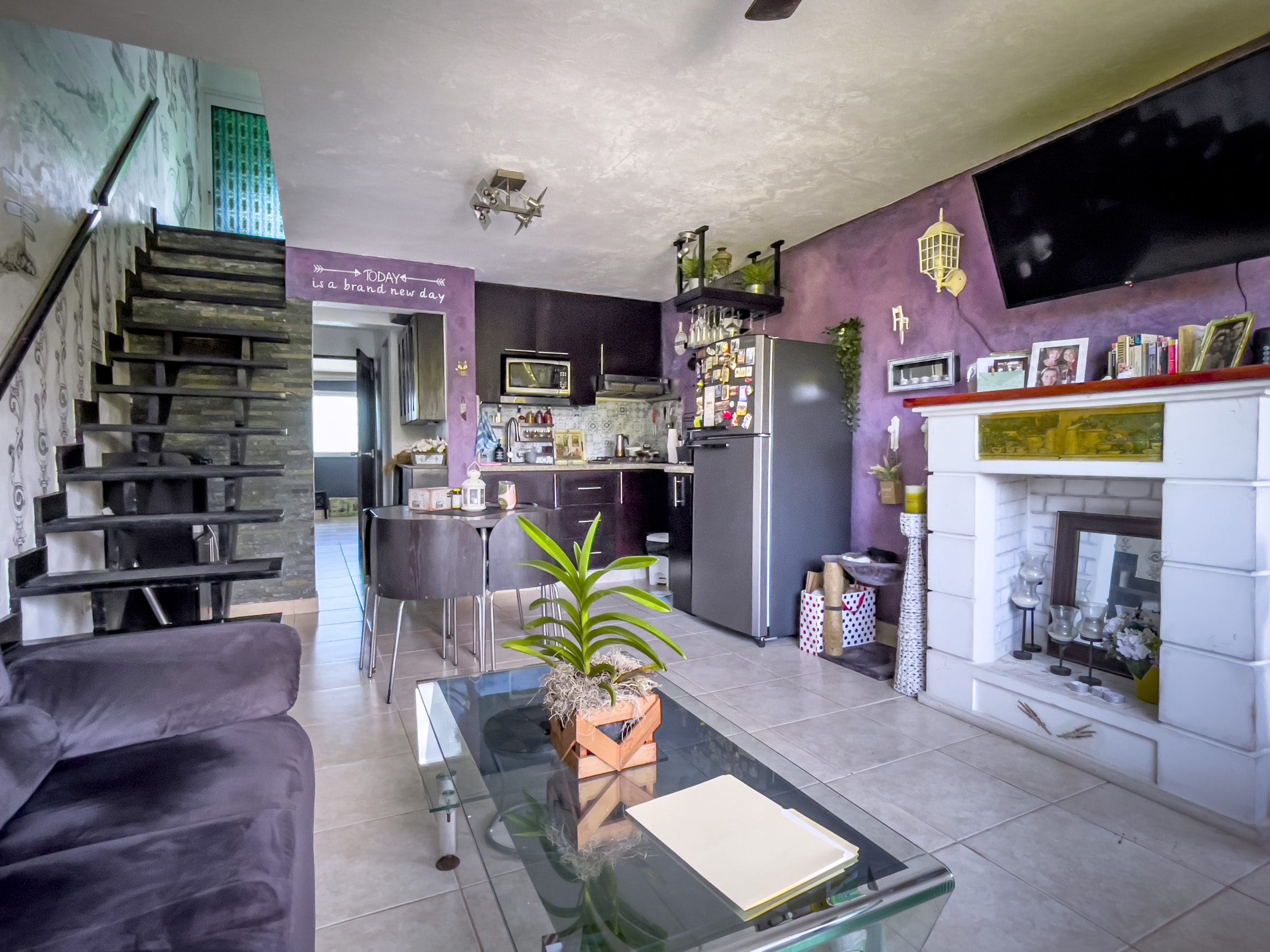 buyDRproperty Living room of a 2 bedroom condo in the heart of Sosua, featuring a fireplace and modern staircase. Sosua Real Estate