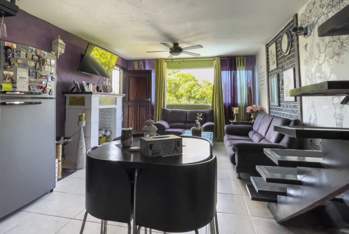 buyDRproperty Living room of a 2 Bedroom Condo in the heart of Sosua. Features a dining table and two sofas. Sosua Real Estate