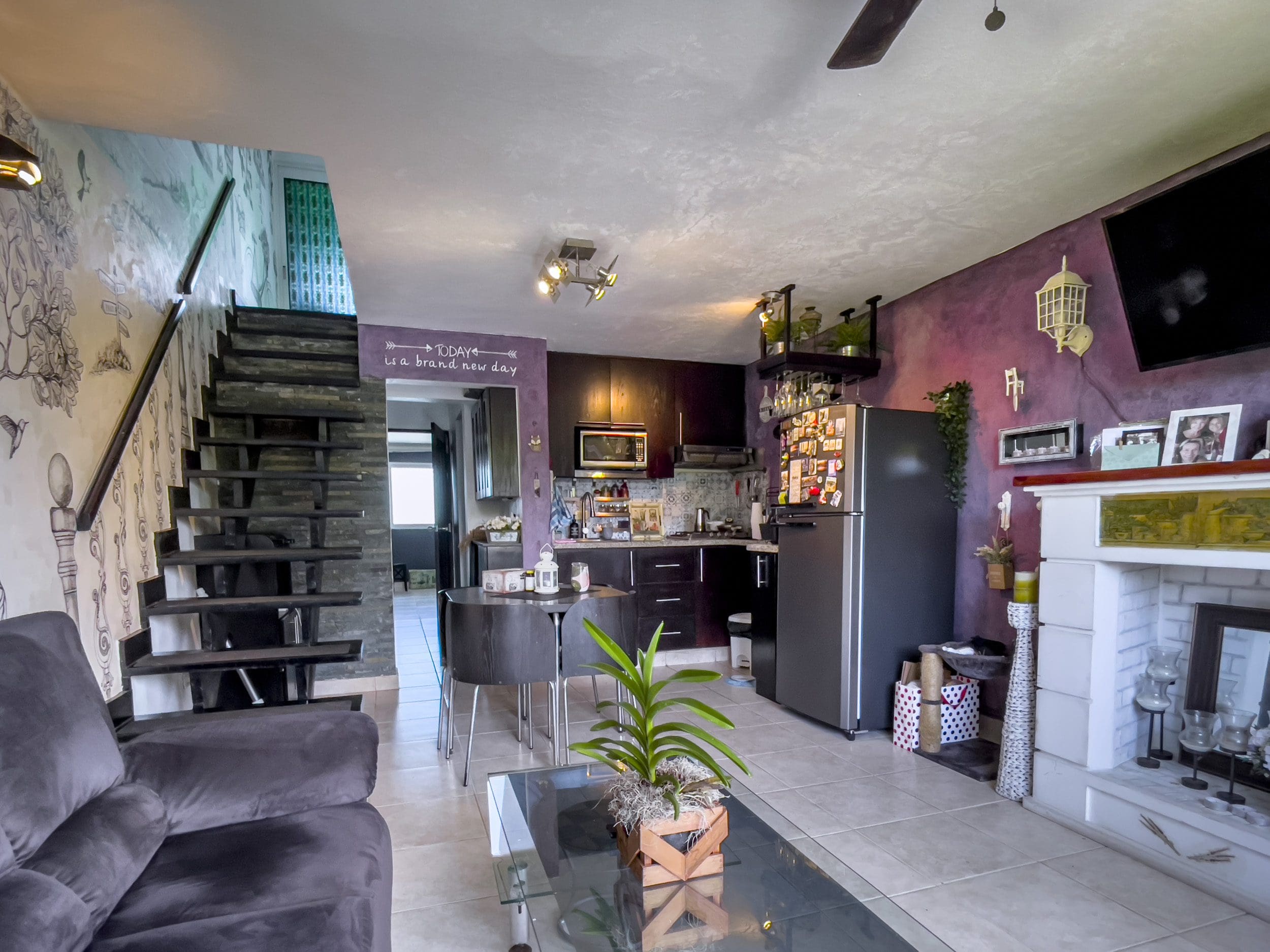 buyDRproperty Living room of a 2 bedroom condo in the heart of Sosua with stairs, kitchen, and fireplace. Sosua Real Estate