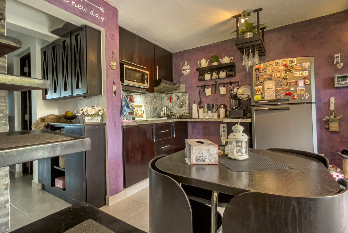 buyDRproperty Kitchen with dark cabinets and dining table in a 2 Bedroom Condo in the heart of Sosua. Sosua Real Estate