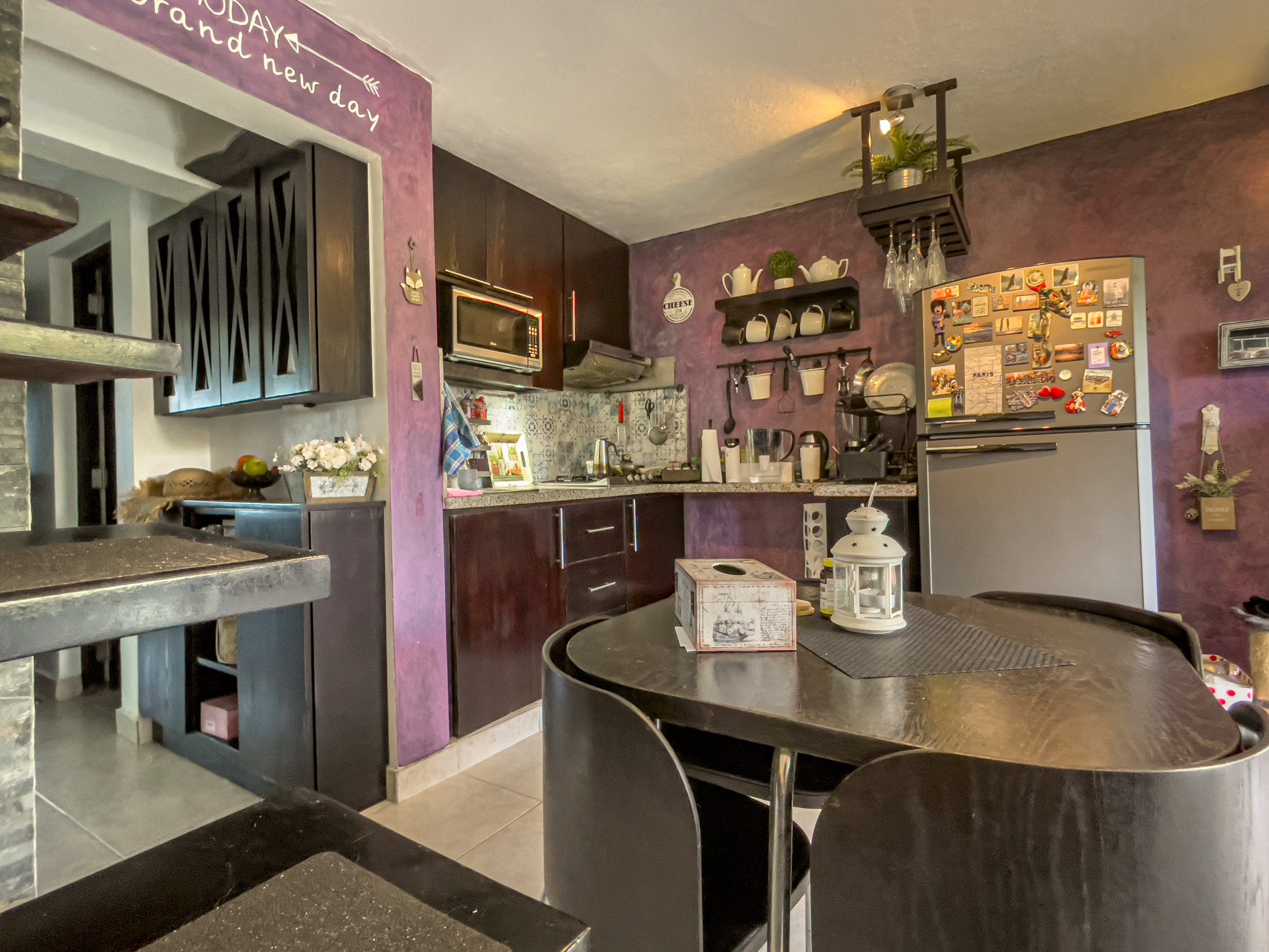 buyDRproperty Kitchen with dark cabinets and dining table in a 2 Bedroom Condo in the heart of Sosua. Sosua Real Estate