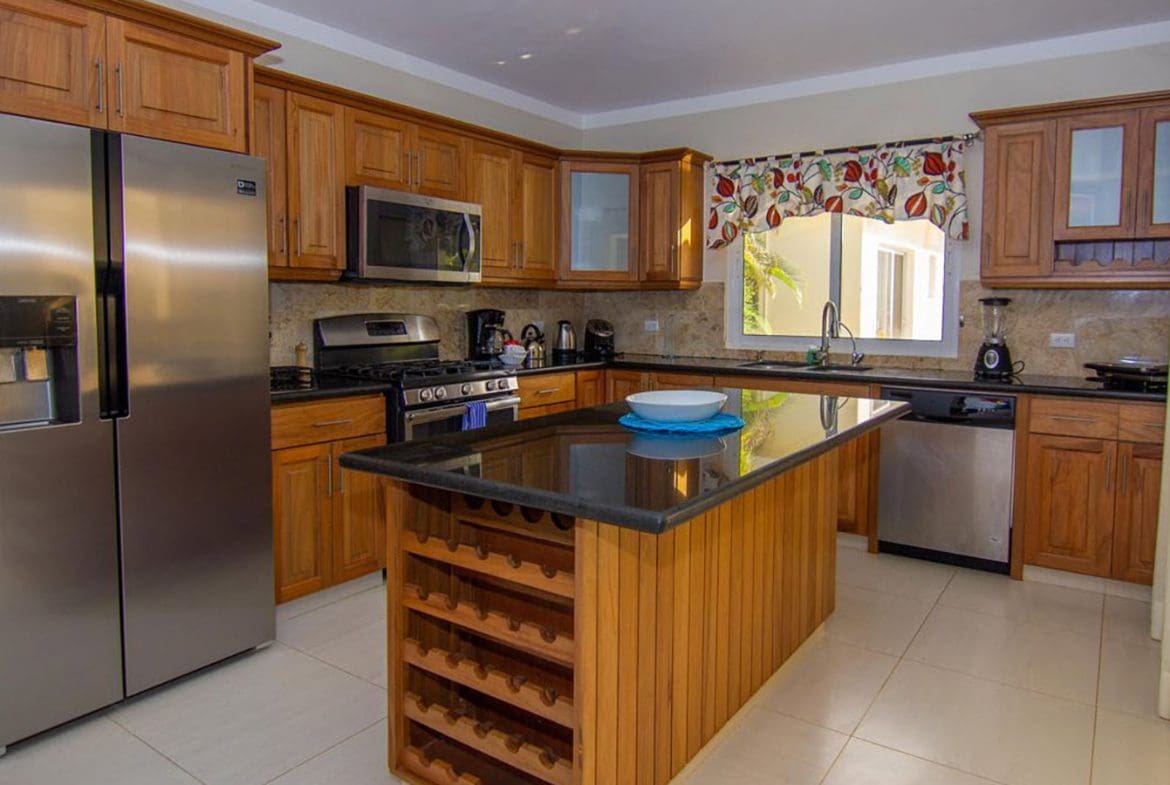 buyDRproperty Beautiful Villa BELLA kitchen with stainless steel appliances and wooden cabinetry in Casa Linda. Sosua Real Estate