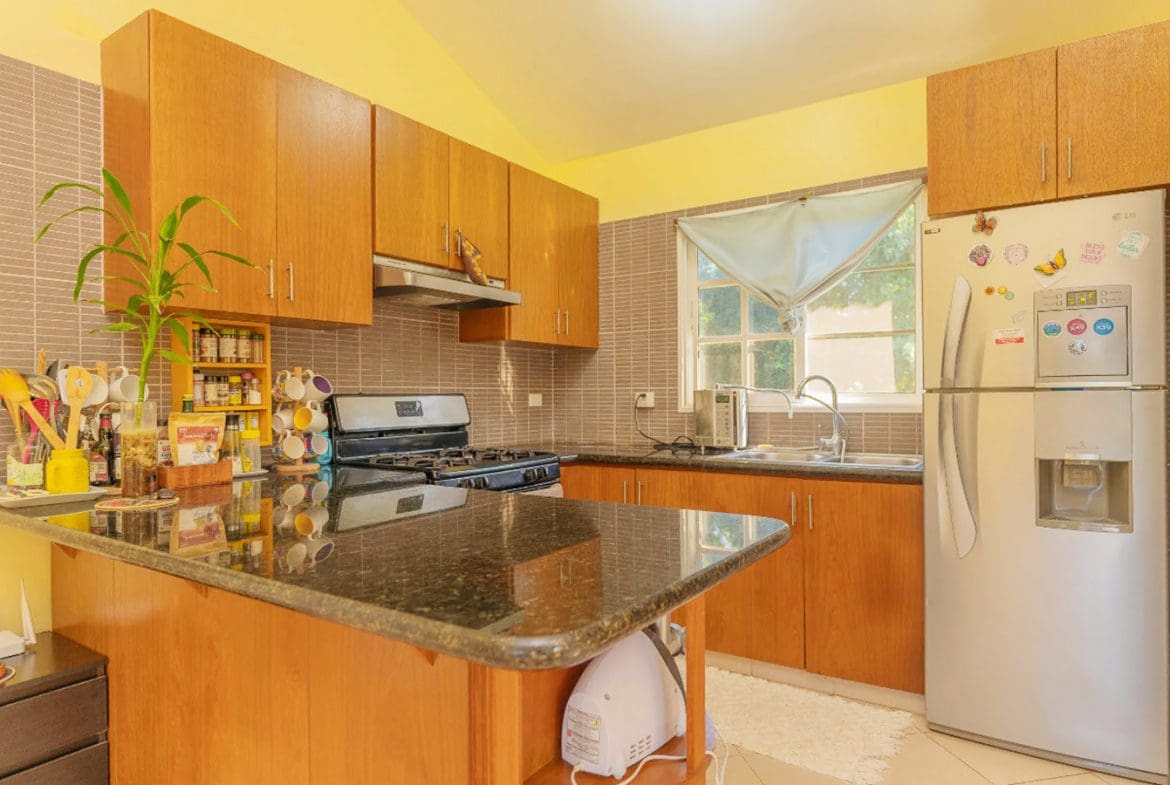 buyDRproperty Kitchen in a Hispaniola Two Unit Villa for sale with wooden cabinets and granite countertops. Sosua Real Estate