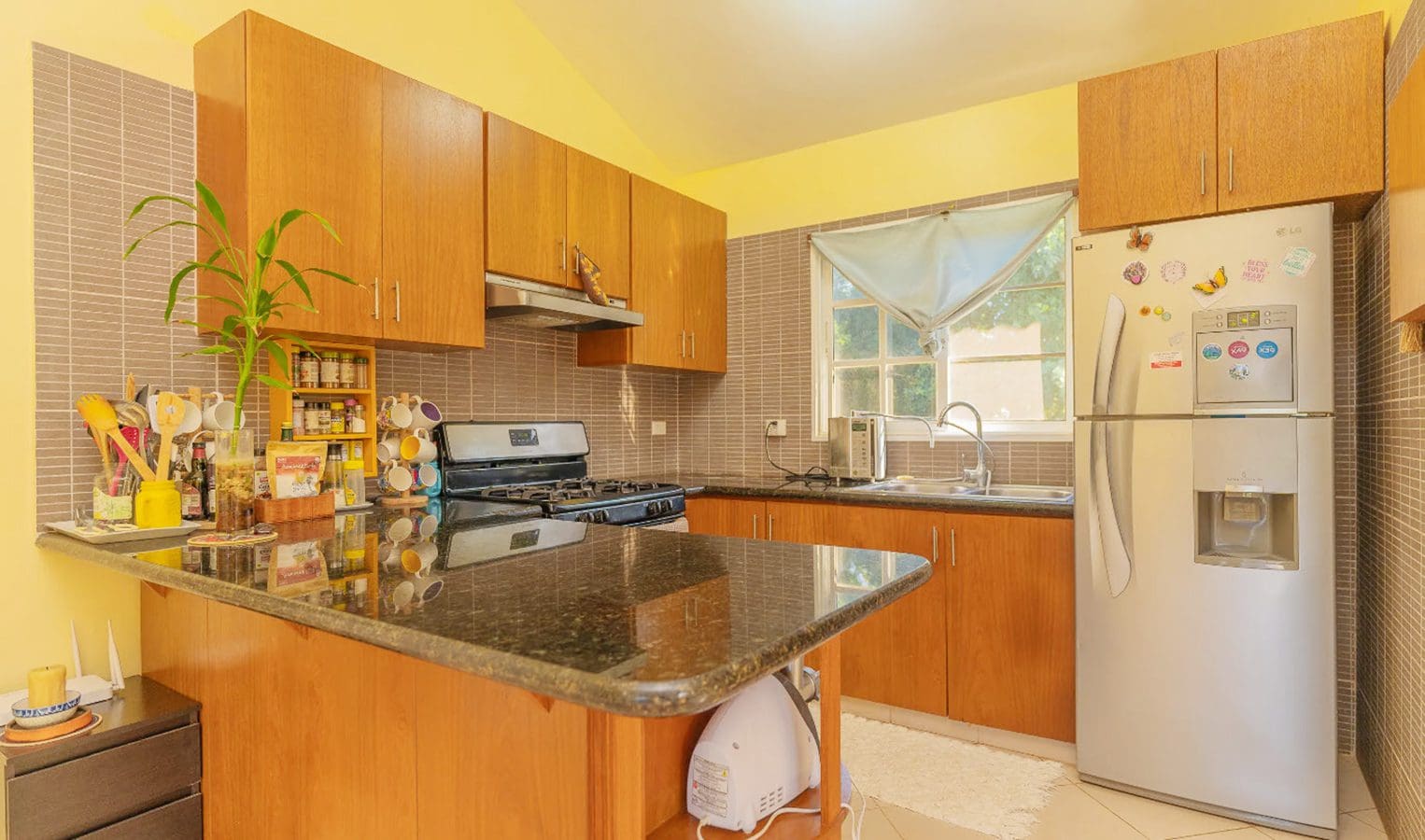 buyDRproperty Kitchen in a Hispaniola Two Unit Villa for sale with wooden cabinets and granite countertops. Sosua Real Estate